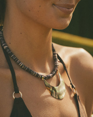 Close-up of a model wearing a necklace with a large pendant.