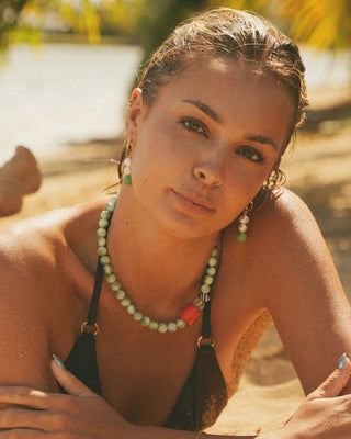Model wearing a statement coral necklace and earrings outdoors
